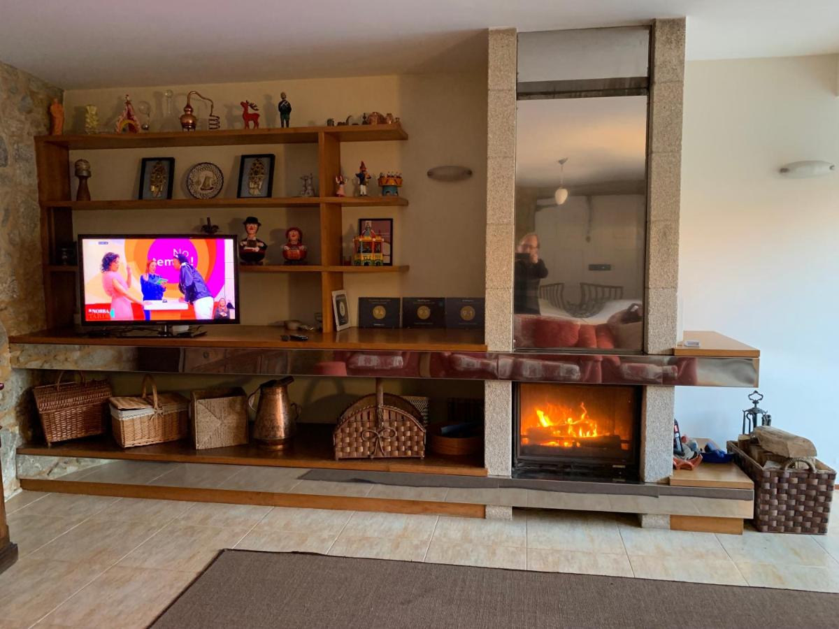Sala com lareira acesa, sofá e móveis rústicos