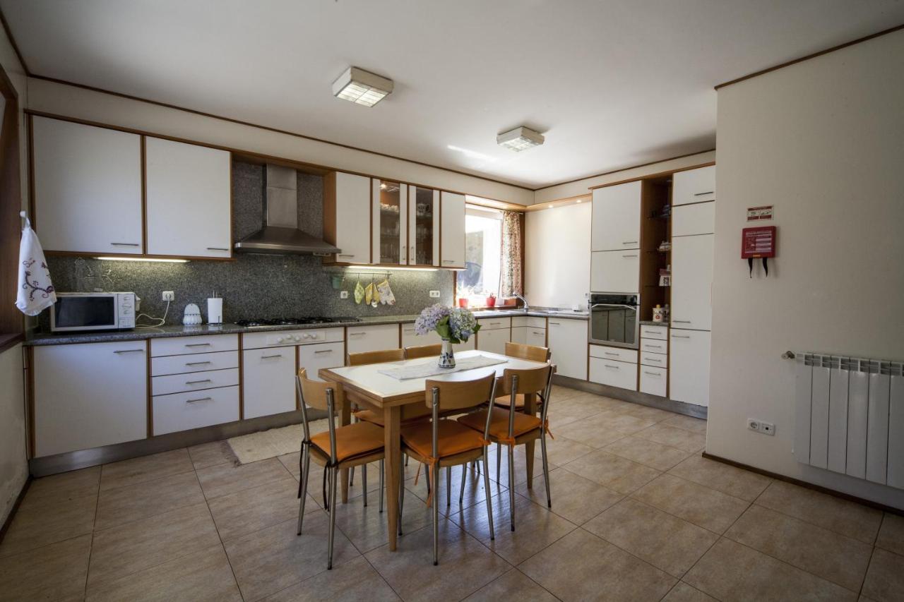 Cozinha totalmente equipada em branco com mesa de refeições